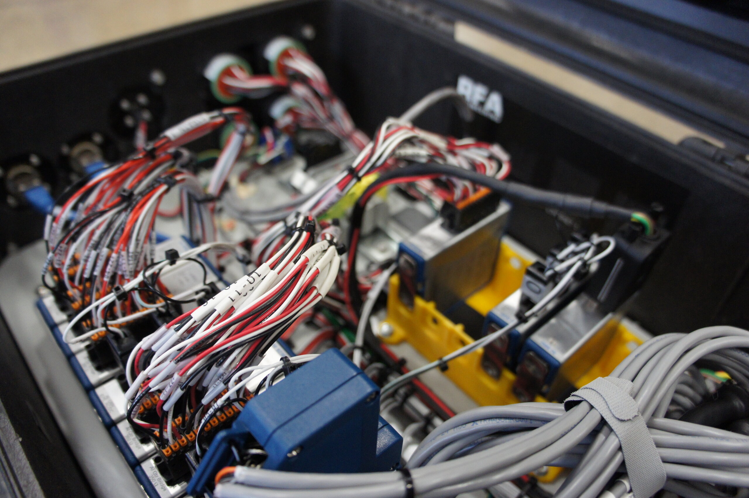 Mess of colorful electrical wires and connectors inside an open equipment cabinet